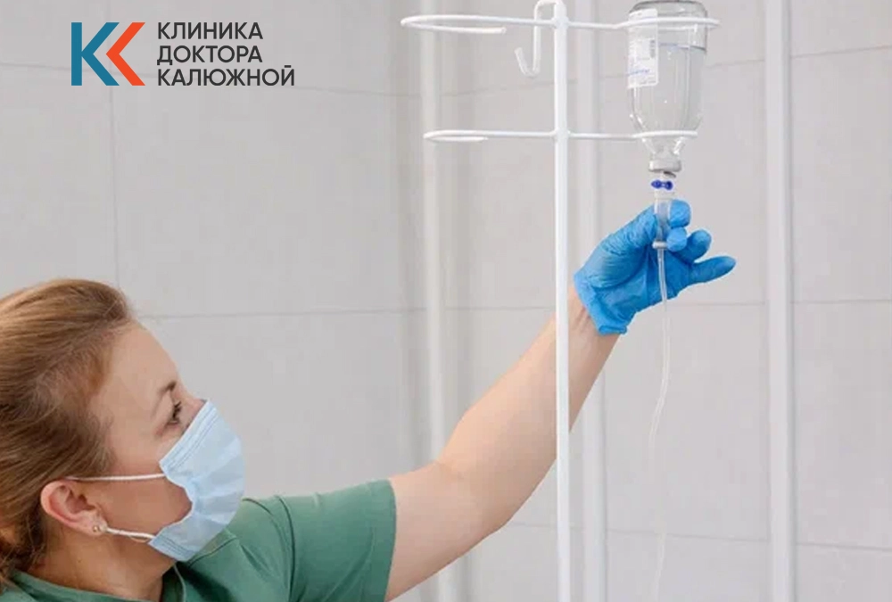 Врач настраивает капельницу в кабинете клиники